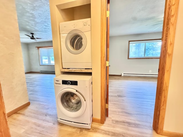 517 2nd St NW, Menahga, MN 56464 - laundry area with stacked washer and clothes dryer, wood finished floors, ceiling fan, a baseboard radiator, and a textured ceiling