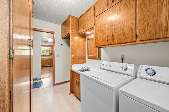 226 Ash Ave, Bird Island, MN 55310 - laundry room featuring washing machine and dryer, cabinet space, and a textured ceiling