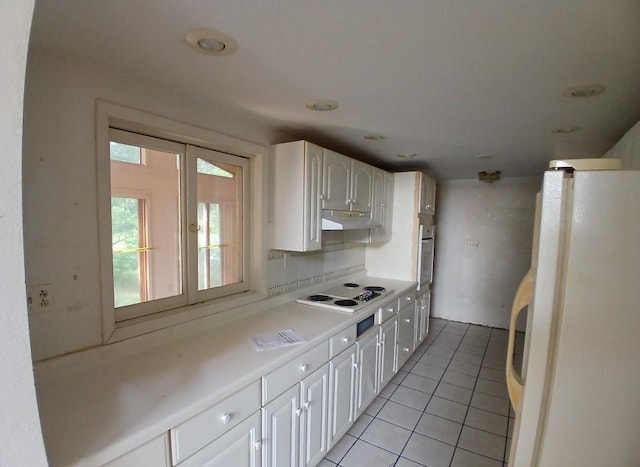 37059 Pinewood Dr, Lawrence Twp, MN 55709 - kitchen featuring white appliances, white cabinetry, under cabinet range hood, light tile patterned floors, and light countertops