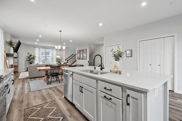 8612 Kenyon Ct NE Unit A, Blaine, MN 55449 - kitchen featuring stainless steel dishwasher, open floor plan, light wood finished floors, an island with sink, and recessed lighting