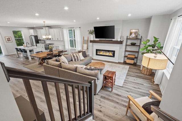 8612 Kenyon Ct NE Unit A, Blaine, MN 55449 - living area with plenty of natural light, light wood finished floors, recessed lighting, and a glass covered fireplace