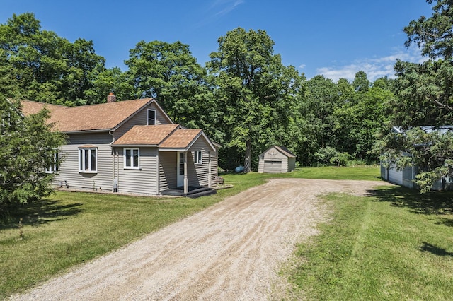 49227 US Highway 59, Dunn Twp, MN 56587 - view of home's exterior with dirt driveway, an outbuilding, a chimney, roof with shingles, and a yard