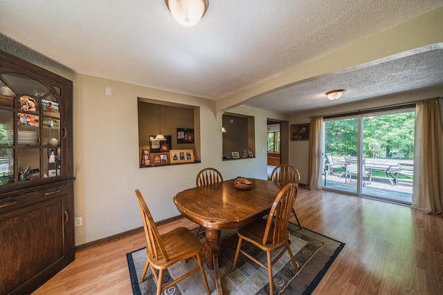 49227 US Highway 59, Dunn Twp, MN 56587 - dining room with light wood-style floors, arched walkways, and a textured ceiling