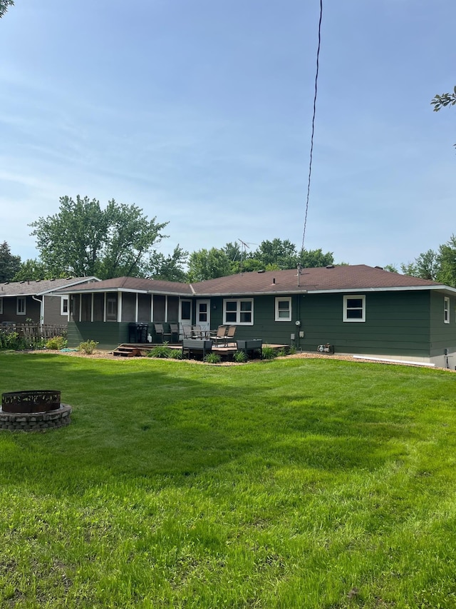 1307 20th St W, Hastings, MN 55033 - rear view of property featuring an outdoor fire pit, a sunroom, and a lawn