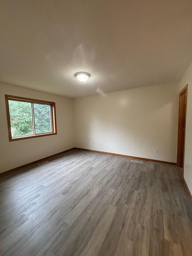 809 Aspen Cir, Waite Park, MN 56387 - spare room featuring wood finished floors and a textured ceiling