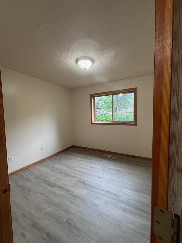 809 Aspen Cir, Waite Park, MN 56387 - empty room with wood finished floors and a textured ceiling