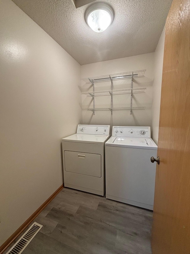 809 Aspen Cir, Waite Park, MN 56387 - laundry area with washer and clothes dryer, wood finished floors, and a textured ceiling