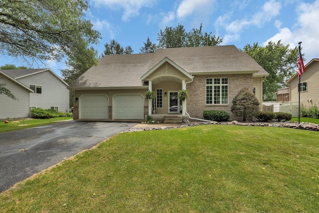 504 3rd St N, Sartell, MN 56377 - view of front facade featuring a garage, asphalt driveway, brick siding, a front yard, and a shingled roof
