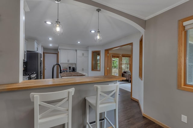 504 3rd St N, Sartell, MN 56377 - kitchen featuring butcher block countertops, freestanding refrigerator, white cabinetry, a peninsula, and dark wood-type flooring