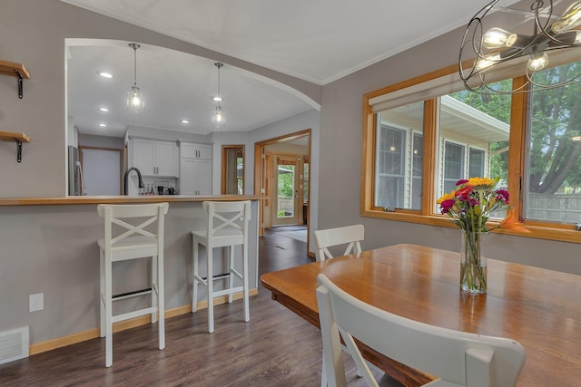 504 3rd St N, Sartell, MN 56377 - dining room featuring dark wood-style flooring, arched walkways, a chandelier, recessed lighting, and crown molding
