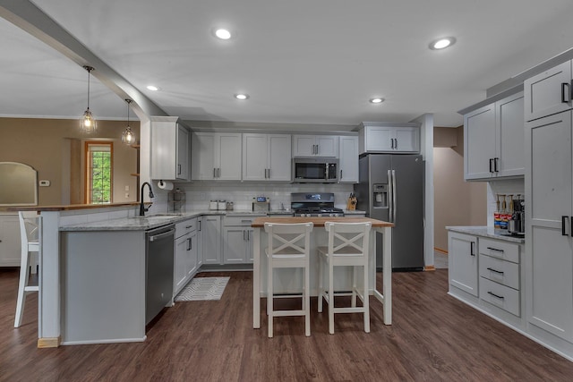 504 3rd St N, Sartell, MN 56377 - kitchen featuring appliances with stainless steel finishes, a kitchen bar, dark wood-style floors, recessed lighting, and ornamental molding