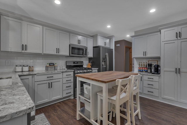 504 3rd St N, Sartell, MN 56377 - kitchen with stainless steel appliances, wooden counters, decorative backsplash, dark wood-type flooring, and recessed lighting