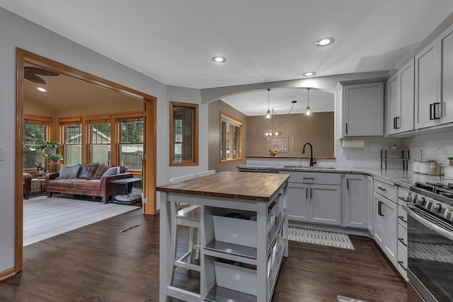 504 3rd St N, Sartell, MN 56377 - kitchen with wooden counters, stainless steel range with gas cooktop, dark wood-style floors, backsplash, and open floor plan