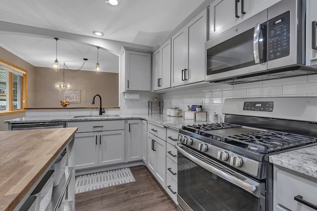 504 3rd St N, Sartell, MN 56377 - kitchen with appliances with stainless steel finishes, butcher block countertops, recessed lighting, dark wood-style flooring, and tasteful backsplash