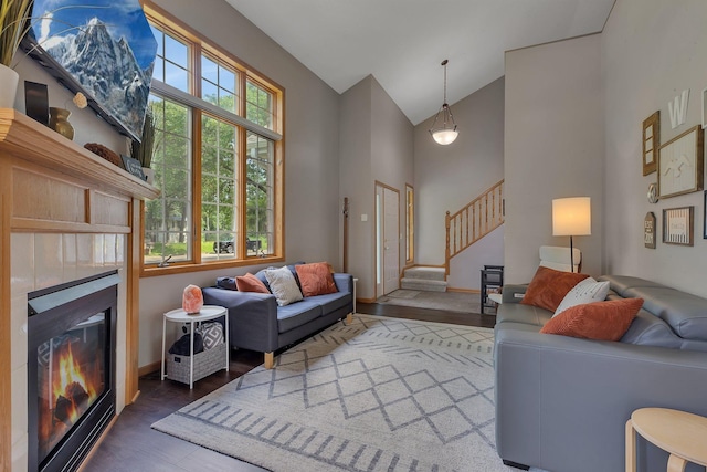 504 3rd St N, Sartell, MN 56377 - living area featuring wood finished floors, stairway, high vaulted ceiling, and a glass covered fireplace