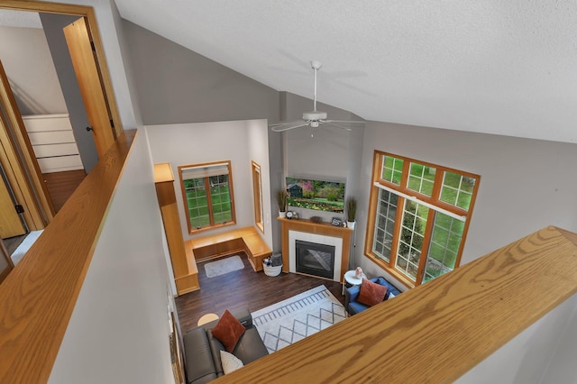 504 3rd St N, Sartell, MN 56377 - living area with lofted ceiling, a tile fireplace, ceiling fan, wood finished floors, and a textured ceiling