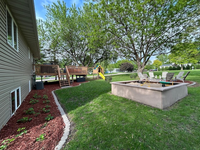 605 Park Island Dr SW, Hutchinson, MN 55350 - view of grassy yard featuring a playground, a wooden deck, and a fire pit