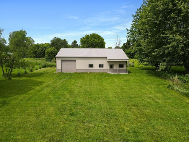 559 State Highway 35, East Farmington, WI 54020 - back of property featuring an outbuilding, a lawn, a metal roof, and a garage