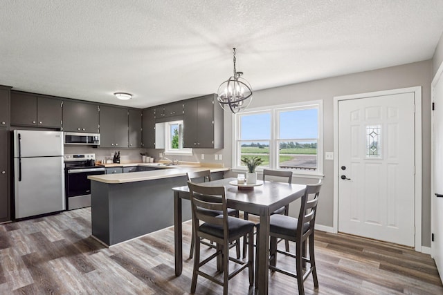 559 State Highway 35, East Farmington, WI 54020 - kitchen with stainless steel appliances, a peninsula, dark wood finished floors, a textured ceiling, and light countertops