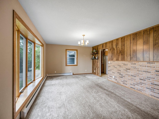 8545 70th St NW, Annandale, MN 55302 - empty room with a baseboard radiator, light carpet, a chandelier, wood walls, and a textured ceiling
