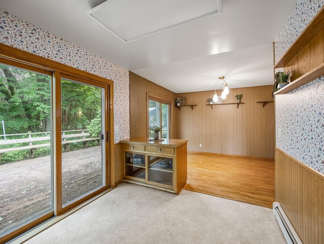 8545 70th St NW, Annandale, MN 55302 - unfurnished dining area with baseboard heating, wooden walls, light wood finished floors, wallpapered walls, and a chandelier