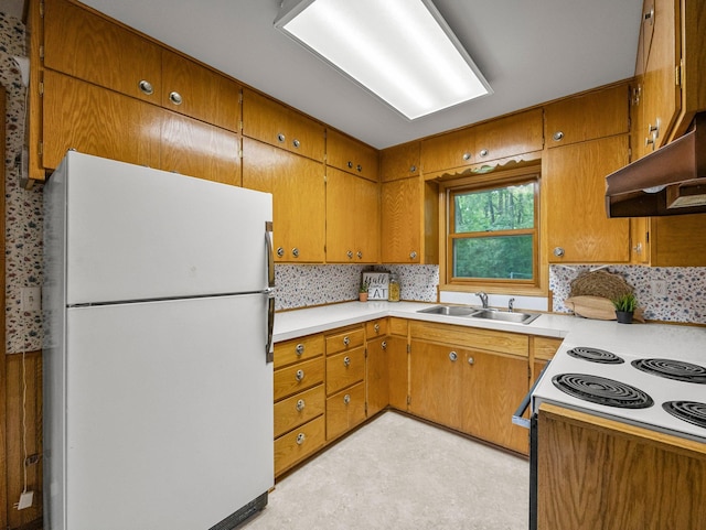 8545 70th St NW, Annandale, MN 55302 - kitchen featuring freestanding refrigerator, backsplash, brown cabinetry, under cabinet range hood, and light countertops