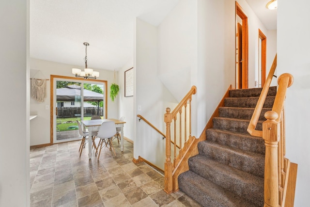 608 Frontier Cir, Belle Plaine, MN 56011 - stairway featuring a chandelier and stone finish floors