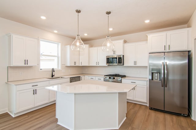 18665 Kennedy St NW, Elk River, MN 55330 - kitchen featuring stainless steel appliances, light countertops, a center island, white cabinetry, and recessed lighting