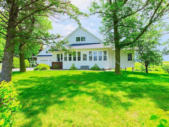 6828 Rhoades Ave SW, Cokato, MN 55321 - rear view of property with entry steps, a lawn, an attached garage, and driveway