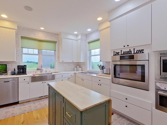 6828 Rhoades Ave SW, Cokato, MN 55321 - kitchen featuring appliances with stainless steel finishes, white cabinets, tasteful backsplash, light countertops, and recessed lighting