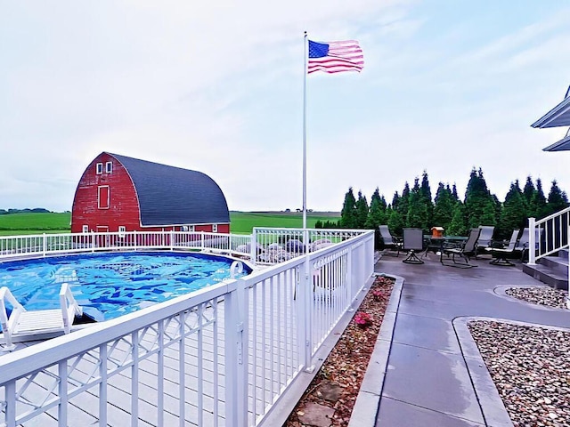 6828 Rhoades Ave SW, Cokato, MN 55321 - view of swimming pool with a barn, a patio area, and an outbuilding