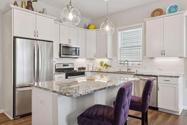 8094 Arrowwood Ln N, Maple Grove, MN 55369 - kitchen featuring appliances with stainless steel finishes, dark wood finished floors, a center island, and tasteful backsplash