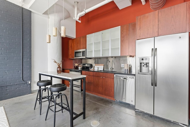 2929 Chicago Ave Unit 1208, Minneapolis, MN 55407 - kitchen with stainless steel appliances, concrete flooring, brown cabinetry, glass insert cabinets, and dark countertops