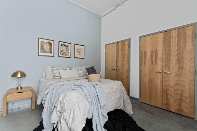 2929 Chicago Ave Unit 1208, Minneapolis, MN 55407 - bedroom featuring concrete flooring, two closets, and a high ceiling