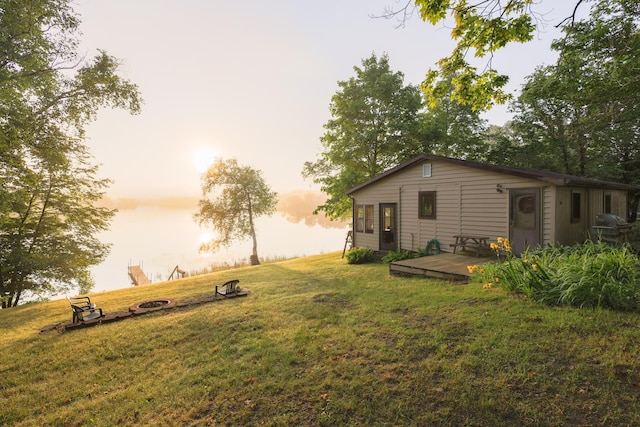 40198 Basswood Ln, Pelican Rapids, MN 56572 - yard at dusk featuring a deck, an outdoor fire pit, and a lawn