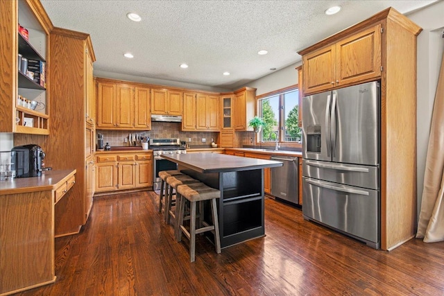 1111 Woods Creek Dr, Delano, MN 55328 - kitchen with appliances with stainless steel finishes, a center island, dark wood-style flooring, backsplash, and a textured ceiling