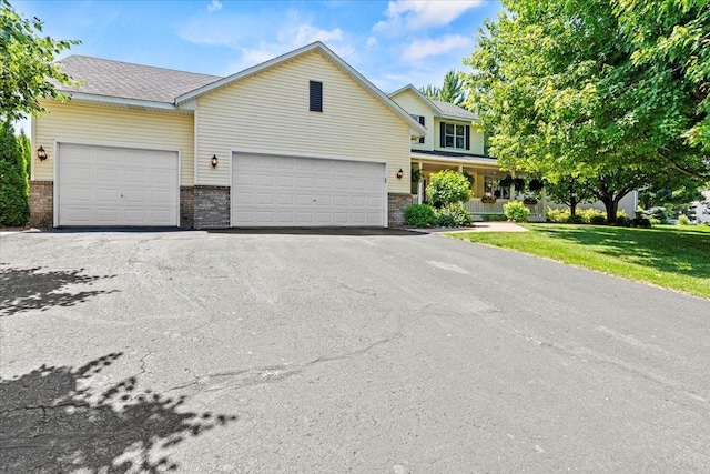 1111 Woods Creek Dr, Delano, MN 55328 - traditional-style home with asphalt driveway, an attached garage, a front yard, and brick siding