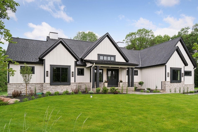 4864 148th Ave, Ham Lake, MN 55304 - modern inspired farmhouse with stone siding, a chimney, a front lawn, covered porch, and board and batten siding