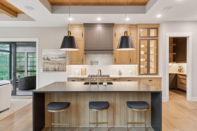 4864 148th Ave, Ham Lake, MN 55304 - kitchen featuring a raised ceiling, light wood-style floors, tasteful backsplash, an island with sink, and recessed lighting