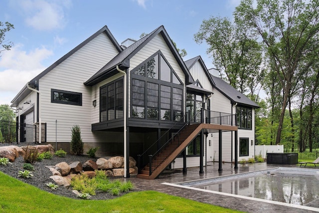 4864 148th Ave, Ham Lake, MN 55304 - back of property featuring a sunroom, stairway, a jacuzzi, an outdoor pool, and an attached garage