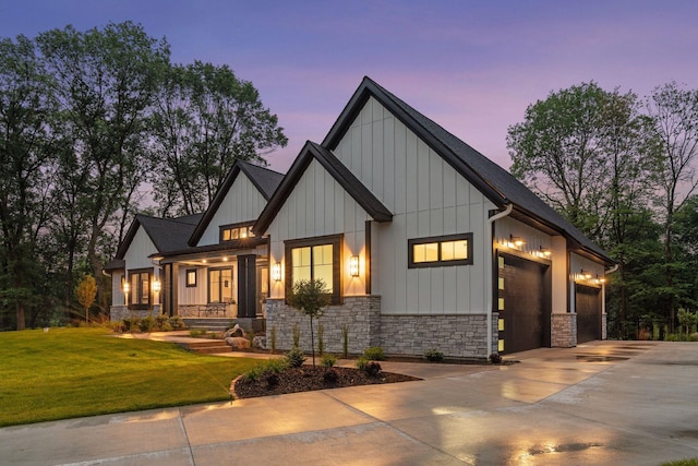 4864 148th Ave, Ham Lake, MN 55304 - modern farmhouse with stone siding, concrete driveway, an attached garage, board and batten siding, and a yard