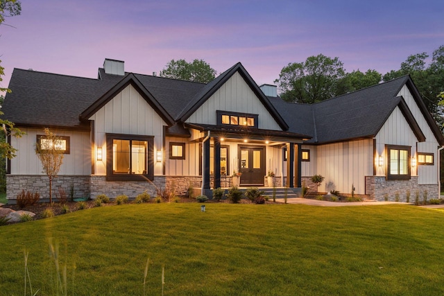 4864 148th Ave, Ham Lake, MN 55304 - view of front facade featuring stone siding, a chimney, a front yard, and board and batten siding