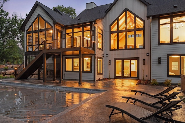 4864 148th Ave, Ham Lake, MN 55304 - back of property at dusk featuring a patio, stairs, a chimney, and board and batten siding