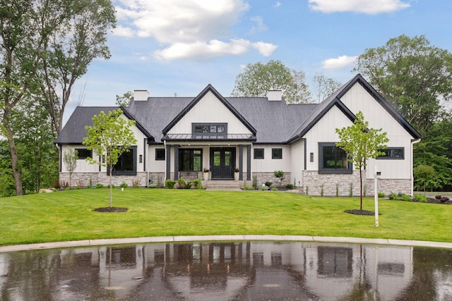 4864 148th Ave, Ham Lake, MN 55304 - view of front of property with a front lawn, stone siding, a standing seam roof, board and batten siding, and roof with shingles
