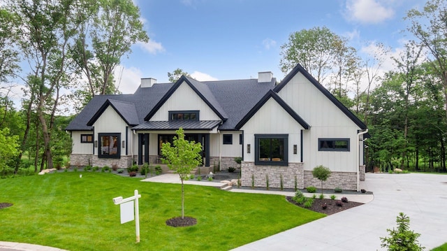 4864 148th Ave, Ham Lake, MN 55304 - modern farmhouse with stone siding, a standing seam roof, a chimney, a front yard, and a metal roof