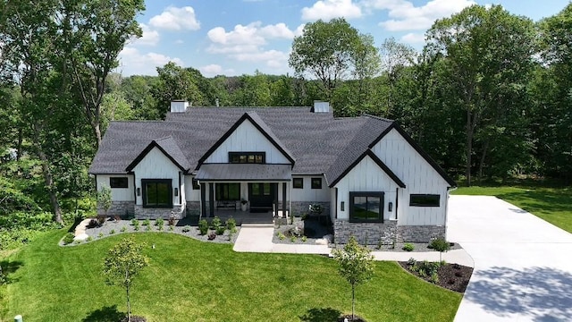 4864 148th Ave, Ham Lake, MN 55304 - modern inspired farmhouse featuring stone siding, a shingled roof, a chimney, and a front lawn