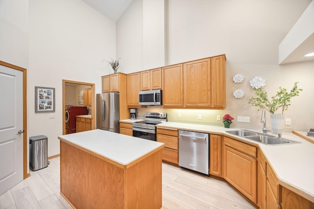 4438 Napier Pkwy NE, Saint Michael, MN 55376 - kitchen with stainless steel appliances, high vaulted ceiling, washing machine and clothes dryer, a center island, and light countertops