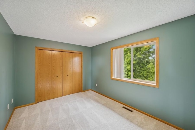 15271 Sodium St NW, Ramsey, MN 55303 - unfurnished bedroom with carpet, a textured ceiling, and a closet