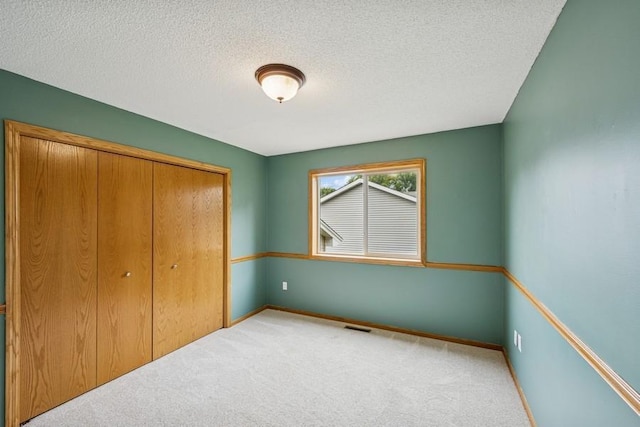 15271 Sodium St NW, Ramsey, MN 55303 - unfurnished bedroom with carpet, a closet, and a textured ceiling