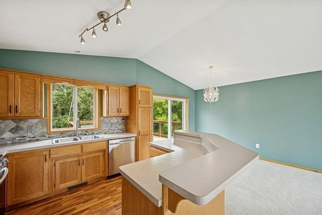 15271 Sodium St NW, Ramsey, MN 55303 - kitchen featuring stainless steel dishwasher, vaulted ceiling, tasteful backsplash, light countertops, and hanging light fixtures
